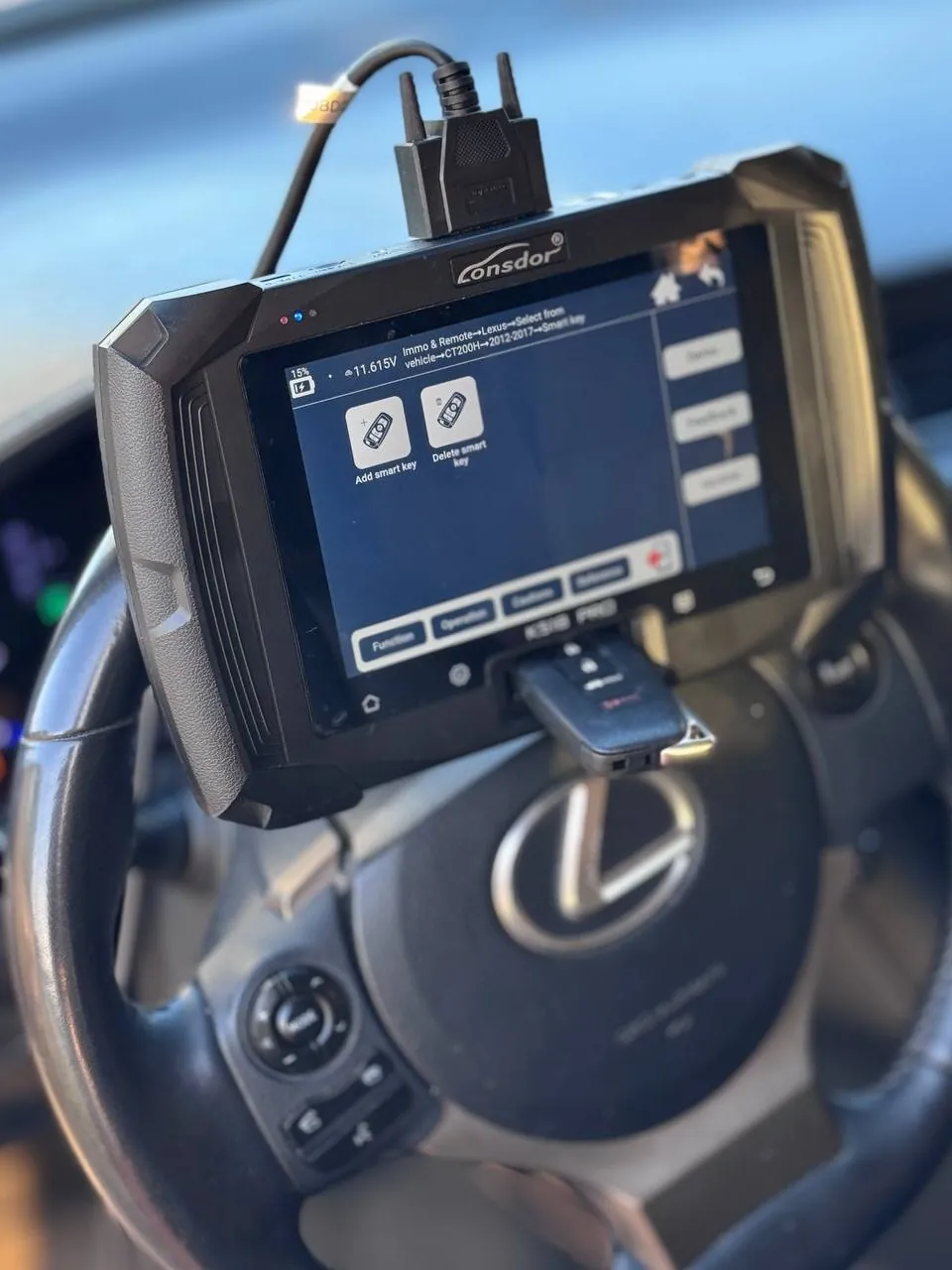 Smart key being added to a Lexus with a key programmer on the steering wheel